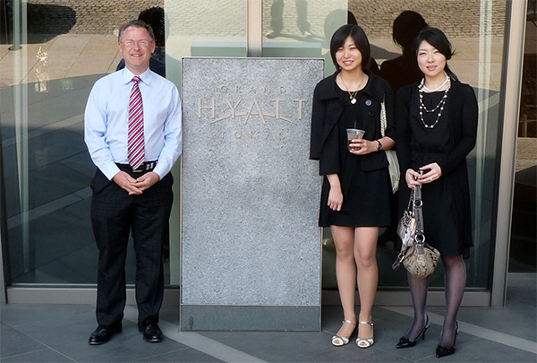 three people standing in front of the Hyatt Tokyo